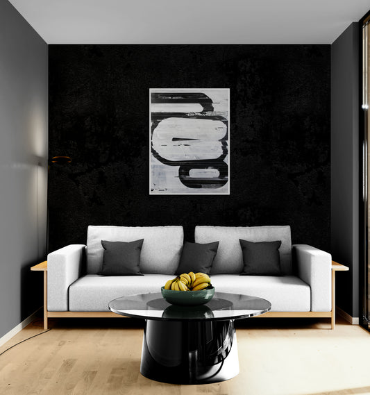 Modern living room with a gray sofa, black coffee table, and abstract art on a black wall.